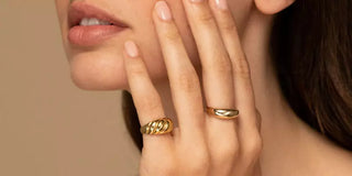 Modern yellow gold jewelry pieces including sleek rings, minimalist earrings, and layered necklaces—showcasing the renewed popularity of warm-toned gold in contemporary design.