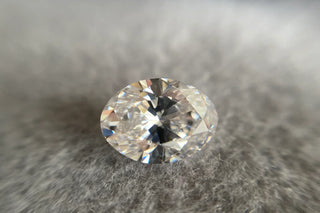 Comparison of an elongated oval cut diamond and a standard oval cut diamond under light—highlighting the darker bowtie-shaped shadow more pronounced in the elongated cut.