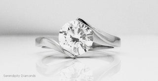 A minimalist engagement ring with an open diamond setting, allowing maximum light to pass through the stone—showcasing the elegance and brilliance of modern, airy ring designs.