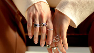 Side-by-side comparison of stainless steel and sterling silver rings on a white background