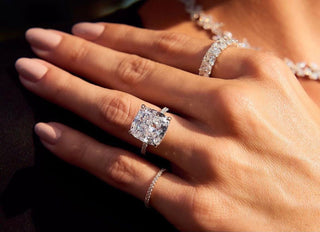 A radiant moissanite ring placed inside a velvet box, shimmering under Dubai sunlight with cityscape reflections in the background. 