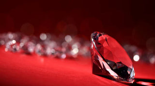 Rough, uncut diamonds on a dark surface symbolizing the ethical issues of conflict gems or blood diamonds.