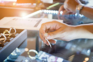 Display case of diamond rings in a luxury jewelry store, reflecting showroom lighting and high retail markups.