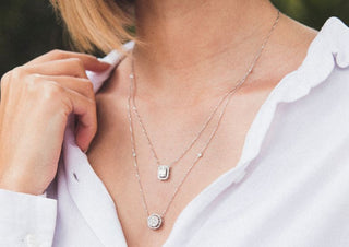 Elegant woman wearing a layered long necklace over a chic outfit, showcasing how statement jewelry adds sophistication and style.