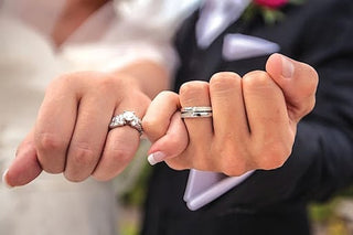 A woman looking concerned while holding her engagement ring, with symbols of bad luck like a broken mirror and black cat in the background—illustrating the belief that certain rings may carry negative energy or superstitions.