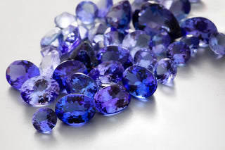 Side-by-side of tanzanite and sapphire gemstones comparing color and value.