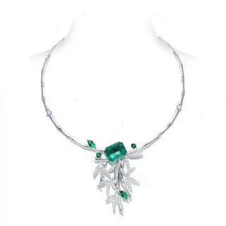 Sculptural sterling silver pendant necklace featuring emerald and white lab sapphires in a bamboo-inspired design.