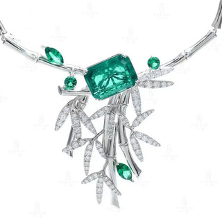 Sculptural sterling silver pendant necklace featuring emerald and white lab sapphires in a bamboo-inspired design.