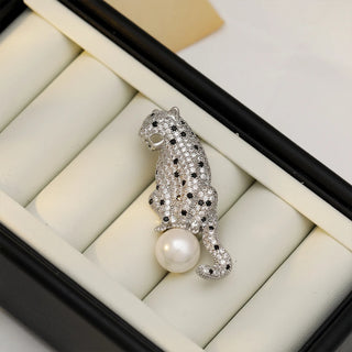 Copper and silver Panther On The Pearl Brooch with lab-created sapphires draped on a luminous pearl, measuring 