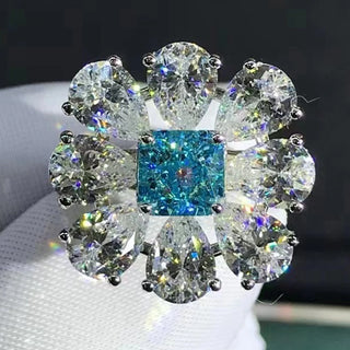 Close-up of Azzallure Frosted Flower Ring featuring a 6-carat aquamarine center stone surrounded by lab-created sapphires, set in 925 sterling silver.

