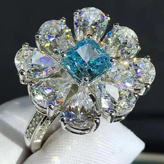 Close-up of Azzallure Frosted Flower Ring featuring a 6-carat aquamarine center stone surrounded by lab-created sapphires, set in 925 sterling silver.
