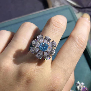 Close-up of Azzallure Frosted Flower Ring featuring a 6-carat aquamarine center stone surrounded by lab-created sapphires, set in 925 sterling silver.

