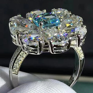 Close-up of Azzallure Frosted Flower Ring featuring a 6-carat aquamarine center stone surrounded by lab-created sapphires, set in 925 sterling silver.

