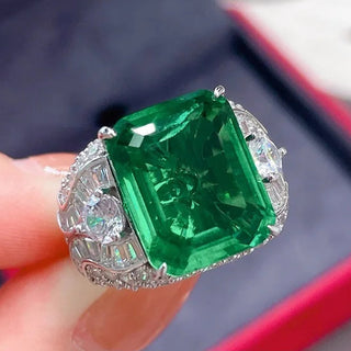 Elegant sterling silver ring with a vivid green emerald-cut lab-created Colombian stone, exuding royal charm and timeless elegance, inspired by heritage and natural beauty.

