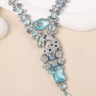 Sterling silver Paraiba Leopard Necklace with vivid sea-blue lab sapphire, pearl-inspired side stones, and a sleek feline design on an O chain.

