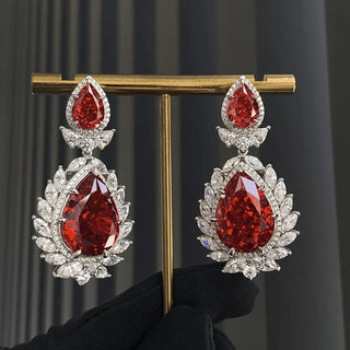 Rouge Teardrop Earrings: 925 sterling silver teardrop earring studs set with lab-created ruby sapphires, weighing 31 grams.
