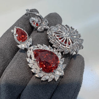 Rouge Teardrop Earrings: 925 sterling silver teardrop earring studs set with lab-created ruby sapphires, weighing 31 grams.