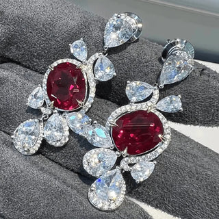 Ruby Waltz Jhumka earrings in 925 sterling silver set with lab-made ruby sapphires and side stones.