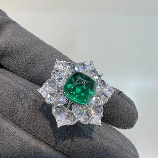 Azzallure Sugar-Loaf Emerald Ring featuring a domed lab-created emerald in a prong setting, flanked by lab sapphires on polished sterling silver.


