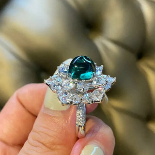 Azzallure Sugar-Loaf Emerald Ring featuring a domed lab-created emerald in a prong setting, flanked by lab sapphires on polished sterling silver.

