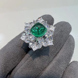 Azzallure Sugar-Loaf Emerald Ring featuring a domed lab-created emerald in a prong setting, flanked by lab sapphires on polished sterling silver.

