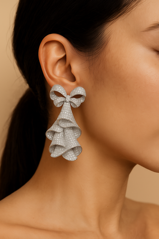 The Drama Bows – Bold sterling silver earrings with shimmering lab-created sapphires and gold or white finish.