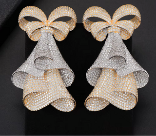 The Drama Bows – Bold sterling silver earrings with shimmering lab-created sapphires and gold or white finish.