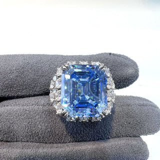 Majestic sterling silver cocktail ring featuring a large emerald-cut aquamarine centerpiece surrounded by lab-created sapphires, evoking the icy brilliance of glaciers and celestial light.
