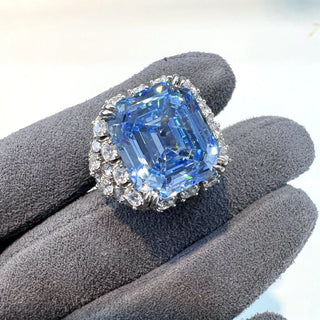 Majestic sterling silver cocktail ring featuring a large emerald-cut aquamarine centerpiece surrounded by lab-created sapphires, evoking the icy brilliance of glaciers and celestial light.